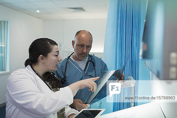 Ärzte besprechen Röntgenbilder im Krankenhauszimmer