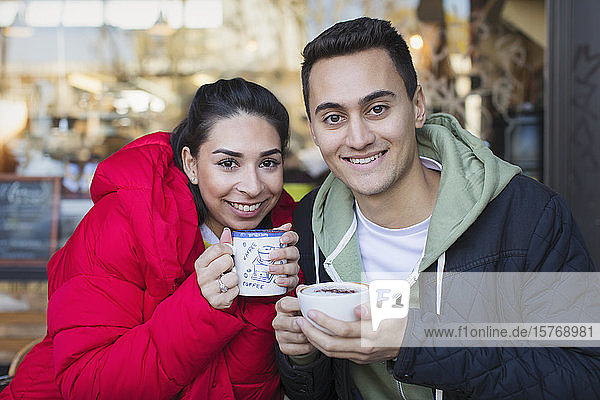 Portrait glückliches junges Paar trinkt Kaffee in einem Straßencafé