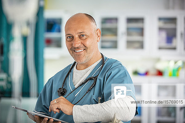 Porträt selbstbewusster männlicher Arzt mit digitalem Tablet im Krankenhaus