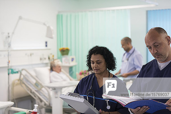 Ärzte mit Krankenblättern bei der Visite  Beratung im Krankenhauszimmer