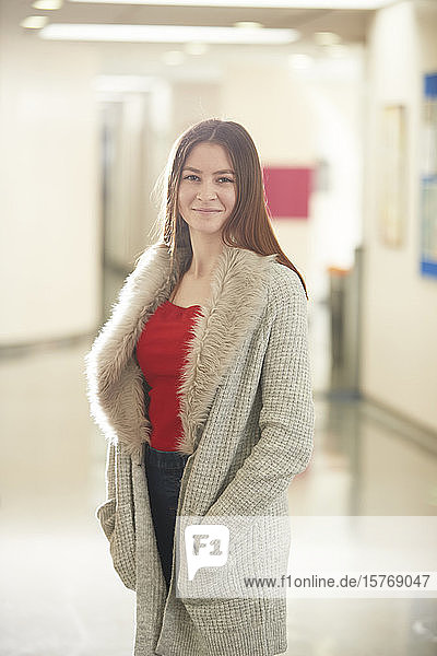 Porträt selbstbewusste junge Studentin im Korridor