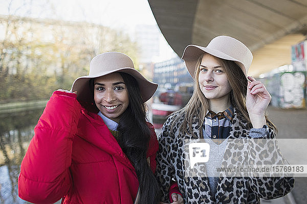 Porträt selbstbewusster junger Frauen mit Filzhüten entlang eines Kanals