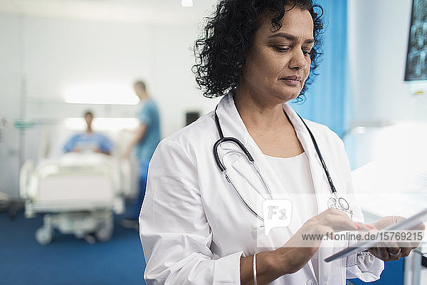 Ärztin mit digitalem Tablet im Krankenhauszimmer
