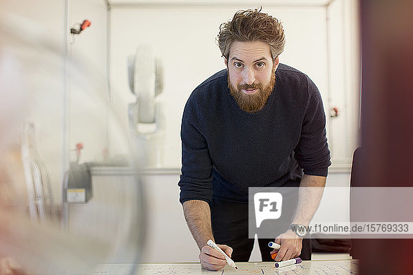 Portrait confident male engineer planning at whiteboard in office