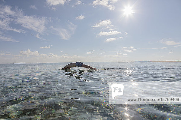 Man diving in sunny  idyllic ocean  Maldives