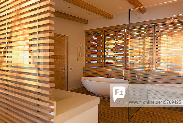 Soaking tub and shower surrounded by wood in modern luxury home showcase interior bathroom