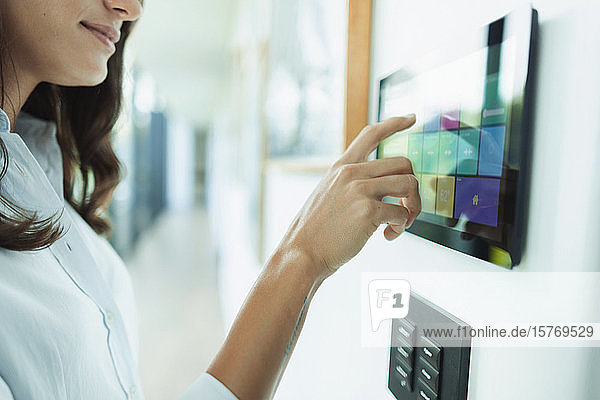 Nahaufnahme einer Frau am Touchscreen der Hausautomatisierung