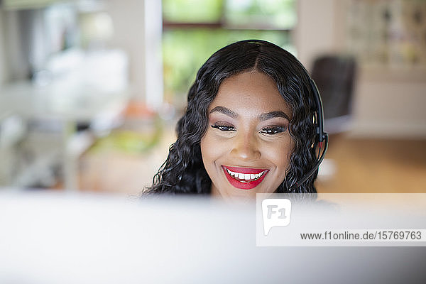 Young woman with headset working at computer