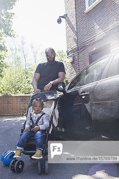 Porträt selbstbewusster Vater und Kleinkind im Kinderwagen