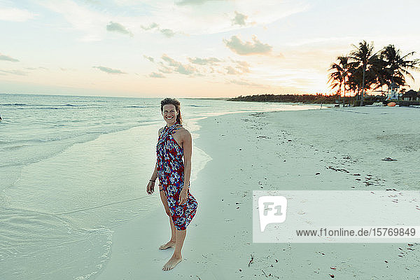 Porträt glückliche Frau in Sonnenkleid auf ruhigen tropischen Ozean Strand Mexiko