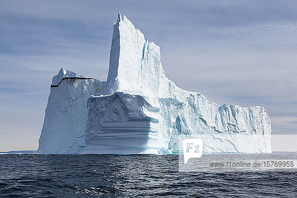 Majestätisch aufragender Eisberg auf dem sonnigen blauen Atlantik Grönlands