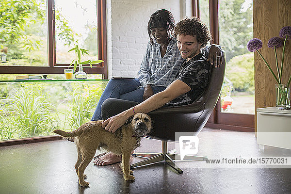 Happy young couple with dog in home office