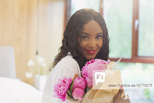 Porträt schöne junge Frau mit Strauß von rosa Pfingstrose Blumen