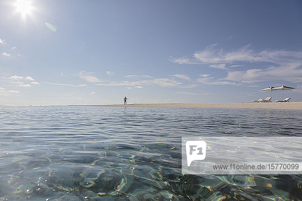 Man standing on sunny  idyllic  remote ocean beach  Maldives