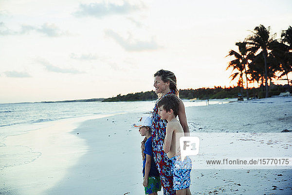 Glückliche Familie entspannt sich am tropischen Ozeanstrand in Mexiko