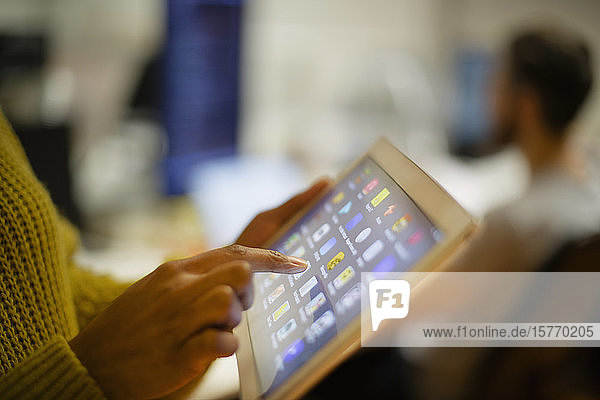 Nahaufnahme einer Frau  die ein digitales Tablet mit Touchscreen benutzt