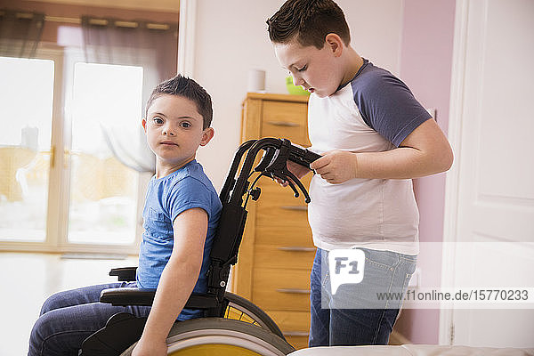 Porträt eines Jungen mit Down-Syndrom im Rollstuhl