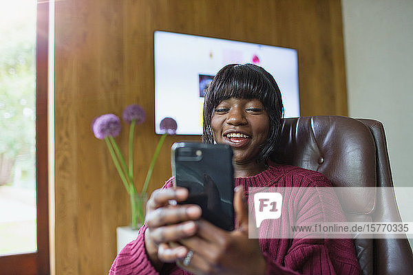 Lächelnde junge Frau mit Smartphone