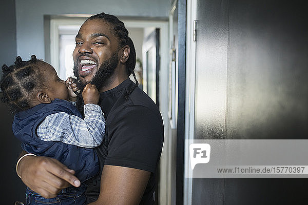Portrait happy father holding toddler son