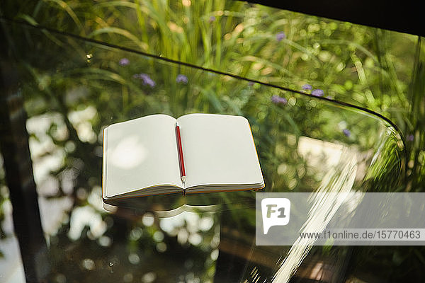 Notebook open to blank pages on glass table