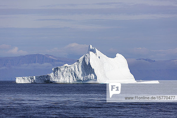 Majestätische Eisbergformation über dem sonnigen blauen Atlantischen Ozean Grönlands