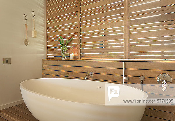 Soaking tub and wood shutters in modern luxury home showcase interior bathroom