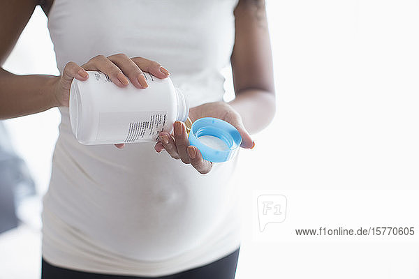 Junge schwangere Frau  die pränatale Vitamine einnimmt