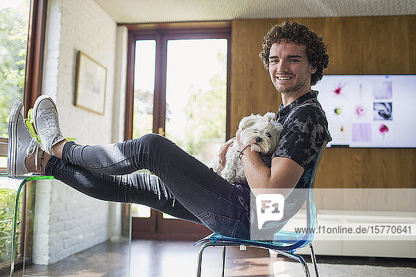 Portrait happy young man with dog in home office