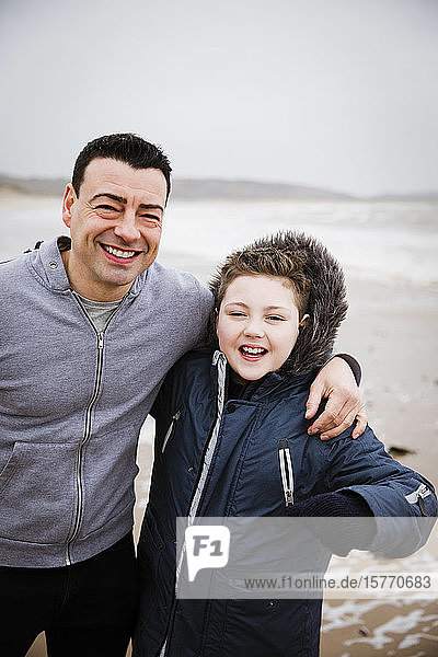 Portrait happy father and son on beach
