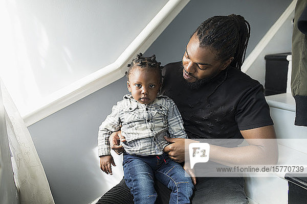 Porträt Vater hält Kleinkind Sohn auf Treppe