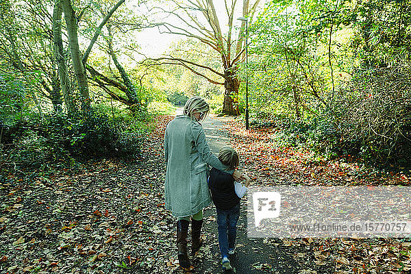 Mutter und Sohn beim Spaziergang in einem idyllischen Herbstpark