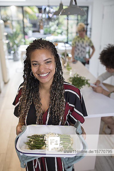 Porträt glückliche Frau kocht Spargel in Küche