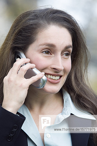 Nahaufnahme einer lächelnden Geschäftsfrau beim Telefonieren.