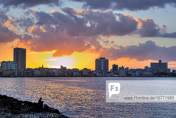 Skyline von Havanna mit Bucht bei Sonnenuntergang und einem einsamen Fischer im Vordergrund; Havanna  Kuba