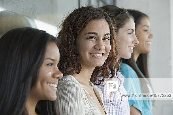Portrait of a teenage girl smiling with her friends beside her