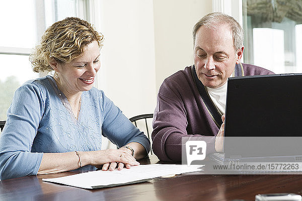 View of a mature couple discussing by table.