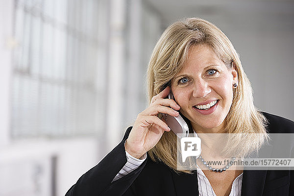 Porträt einer Geschäftsfrau  die ein Mobiltelefon benutzt.