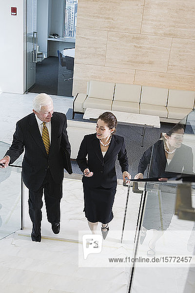Elevated view of businesspeople walking on a staircase in an office.