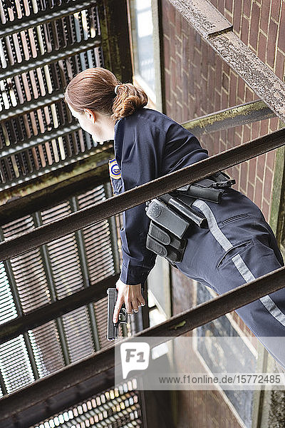 Weiblicher Polizeibeamter mit Waffe in der Hand.