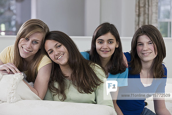 Portrait of four teenage girls sitting on a couch at home