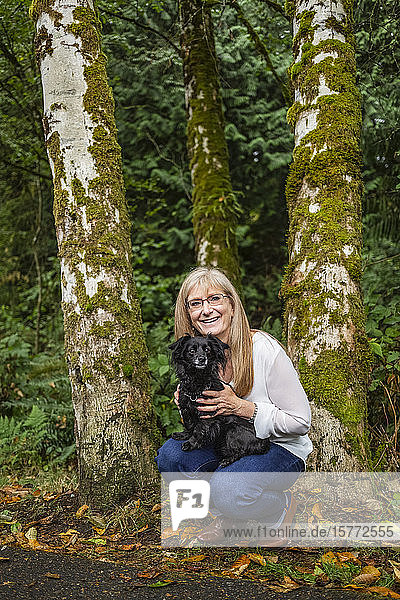 Porträt einer Frau mit ihrem Hund in einem Regenwald; Langley  British Columbia  Kanada