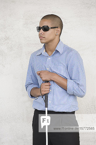 High school student wearing sunglasses and holding a cane