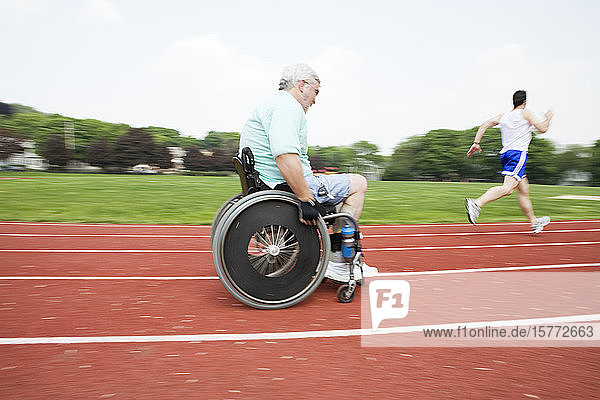 View of a young man racing with a handicapped senior man on a racetrack .