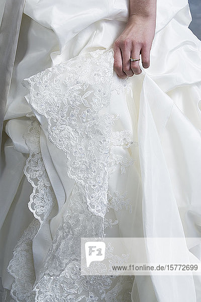Mittelteil der Braut im Hochzeitskleid.