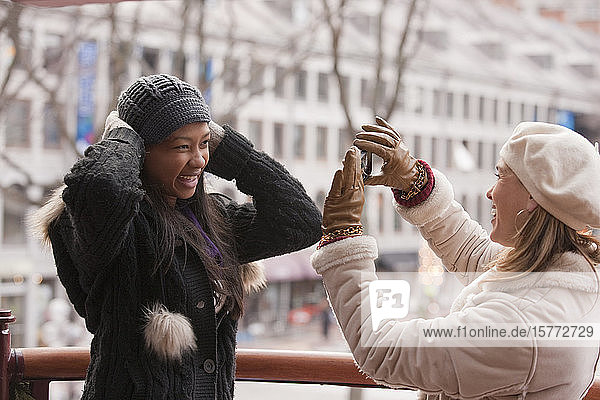 Eine Frau fotografiert einen Freund draußen im Winter; Boston  Massachusetts  Vereinigte Staaten von Amerika