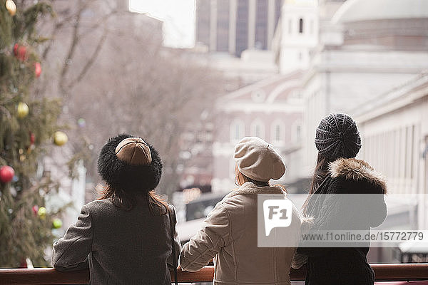 Drei Frauen stehen auf einem Balkon mit Weihnachtsschmuck und blicken auf die Stadt; Boston  Massachusetts  Vereinigte Staaten von Amerika