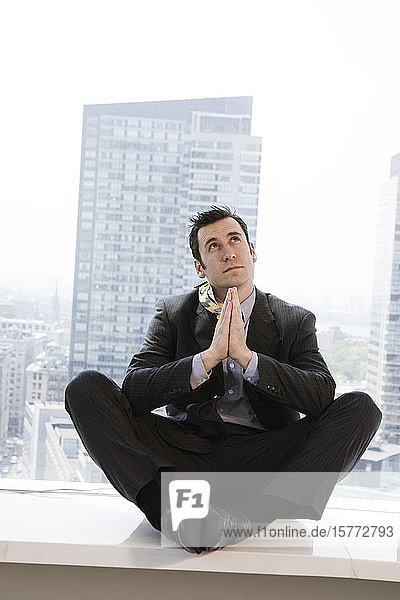 Businessman praying in an office.