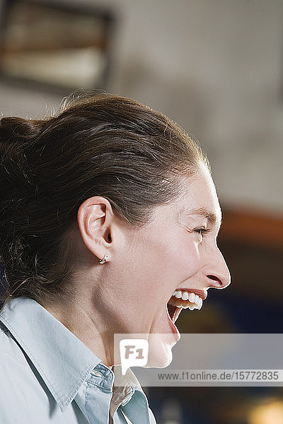 Profil einer lachenden jungen Frau.
