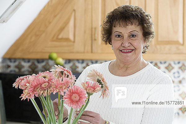 Porträt einer fröhlichen Frau mit Gänseblümchen.