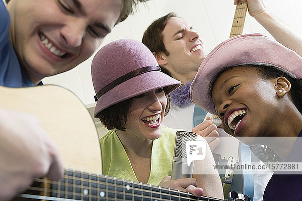 Zwei Männer und zwei Frauen spielen Gitarren.